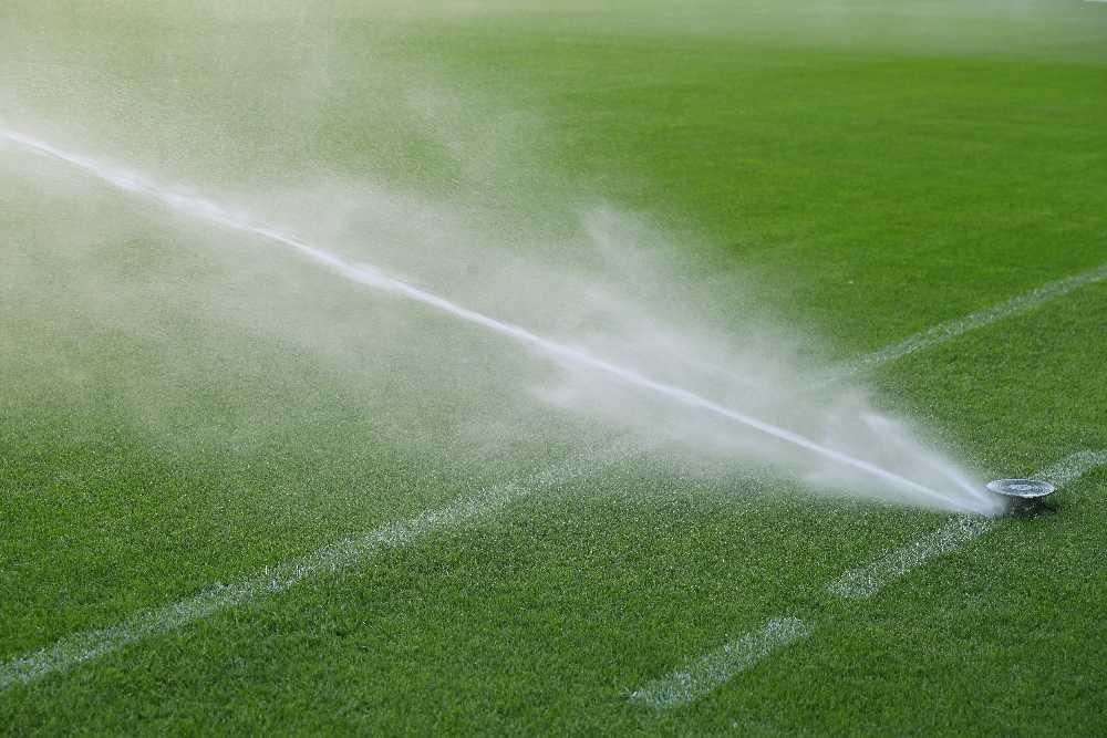 Automatic watering system at a sports stadium. Watering natural lawn grass